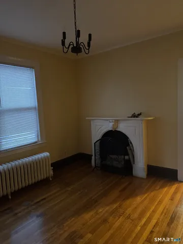 a view of a livingroom with wooden floor and a fireplace