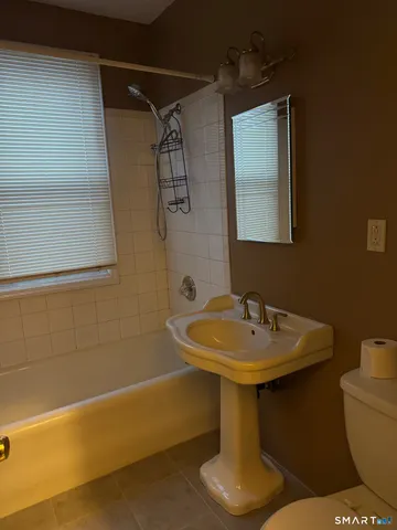 a bathroom with a sink a toilet and mirror