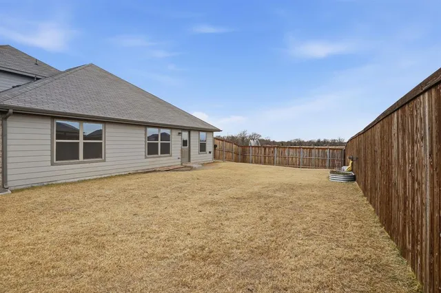 a backyard of a house with wooden fence
