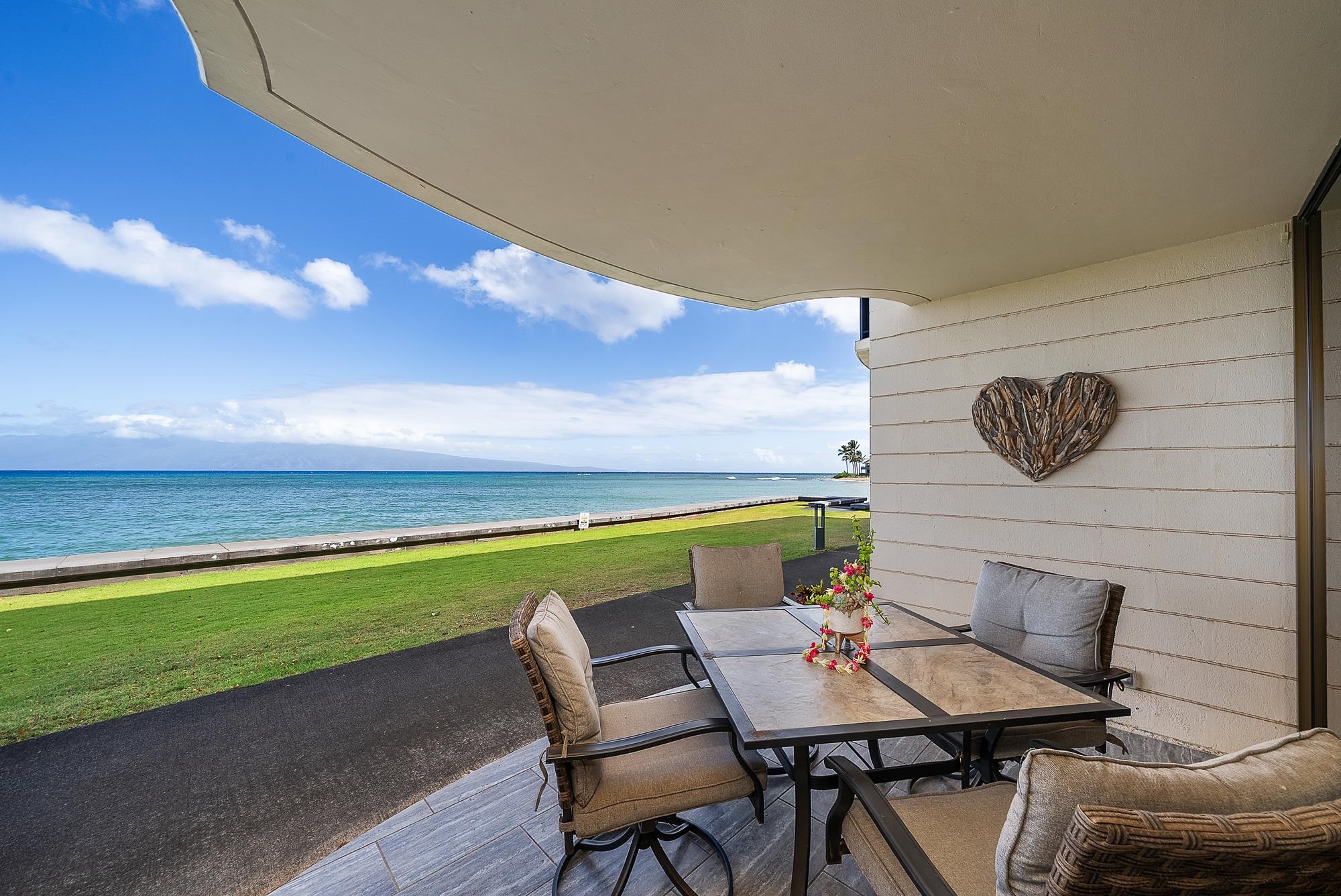 4471 Lower Honoapiilani Road, Unit 118 Lahaina, HI 96761 - Photo 23 of 41 a backyard of a house with table and chairs
