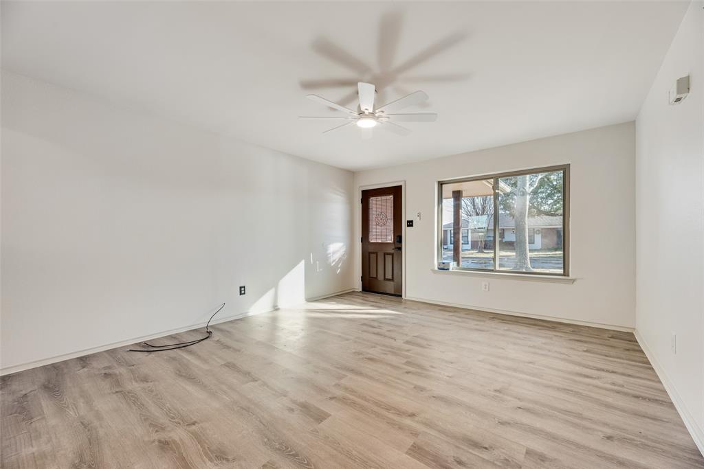605 Cates Drive Kaufman, TX 75142 - Photo 8 of 33 an empty room with wooden floor chandelier fan and windows