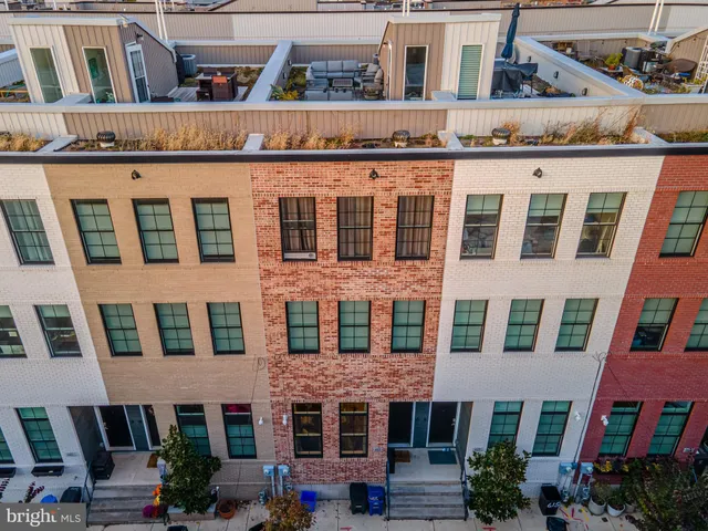 a front view of a building with balcony and outdoor seating