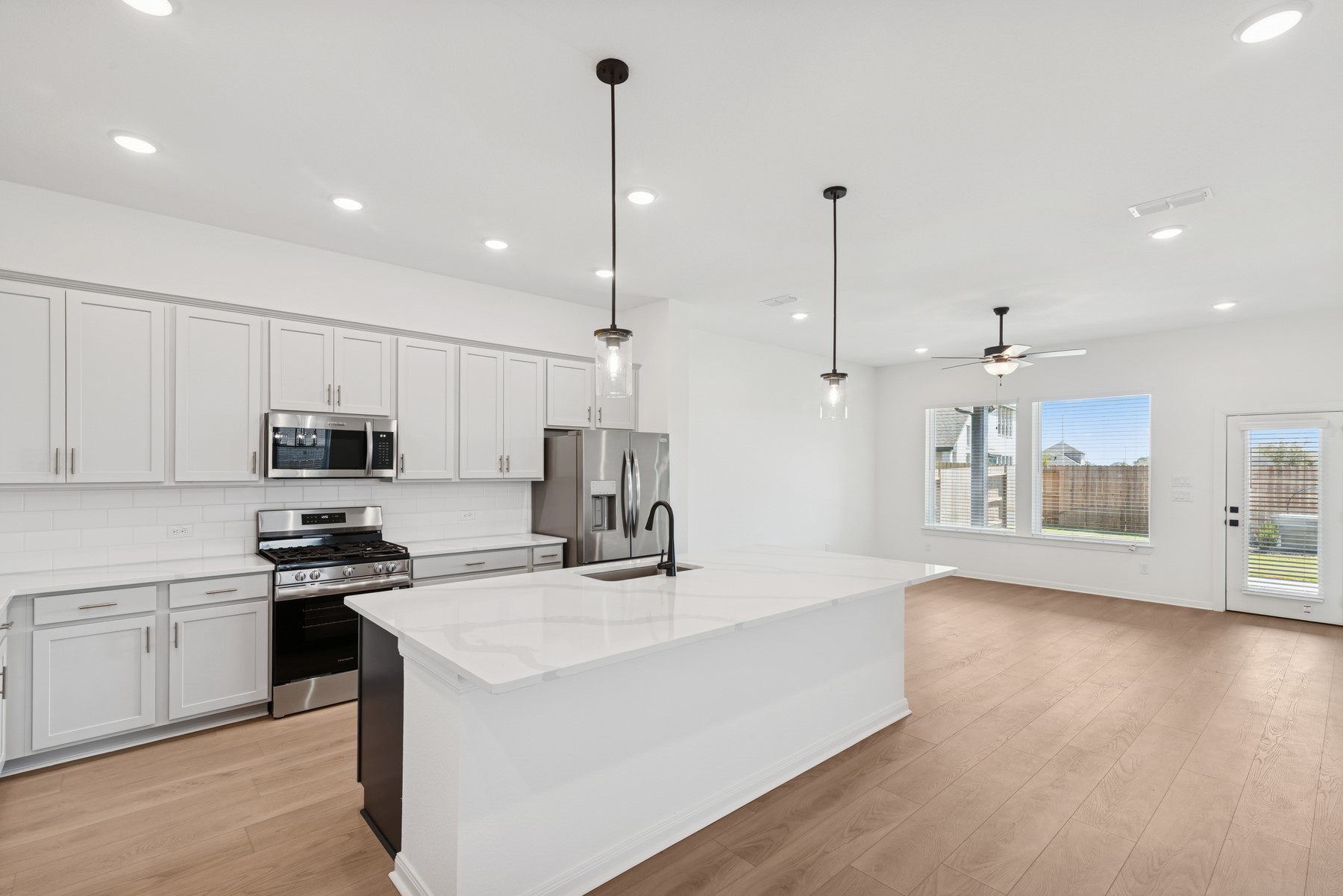 123 Blue River Trail Rosenberg, TX 77471 - Photo 24 of 46 a kitchen with kitchen island white cabinets stainless steel appliances and a counter top