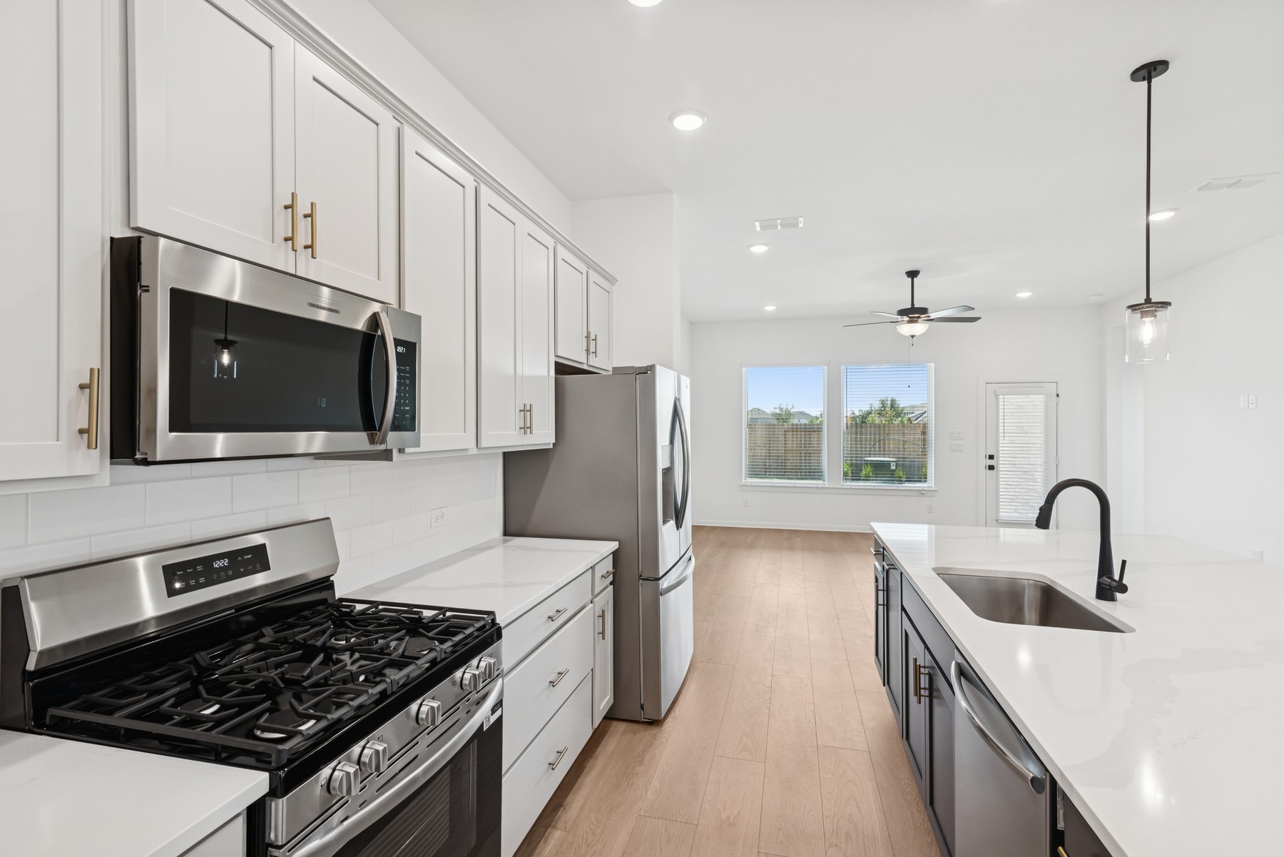 123 Blue River Trail Rosenberg, TX 77471 - Photo 28 of 46 a kitchen with stainless steel appliances a stove a sink and a microwave