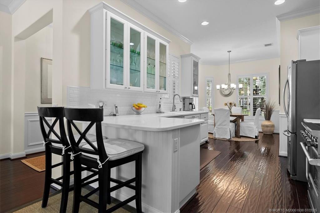 a kitchen with stainless steel appliances wooden floor dining table and chairs