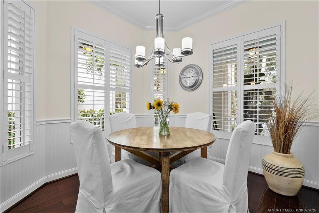 107 Castries Drive Jupiter, FL 33458 - Photo 18 of 39 a dining room with wooden floor a chandelier a wooden table and chairs