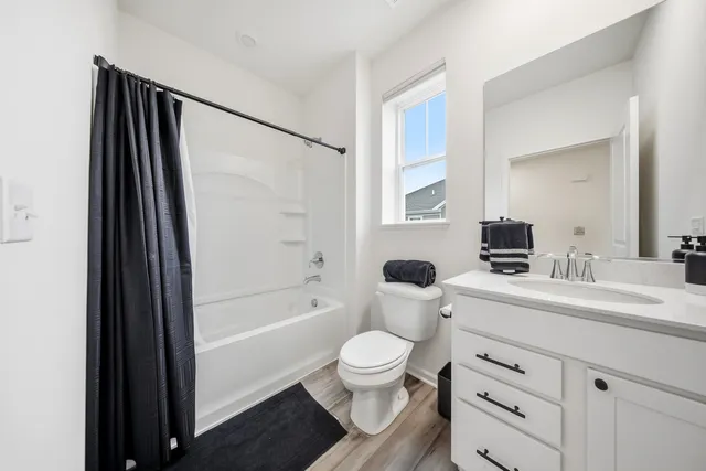 a bathroom with a sink a toilet a mirror and shower