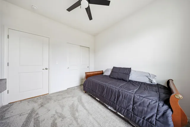 a bedroom with a large bed and a ceiling fan