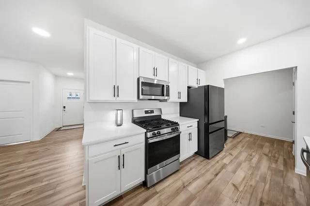 a kitchen with white cabinets and stainless steel appliances