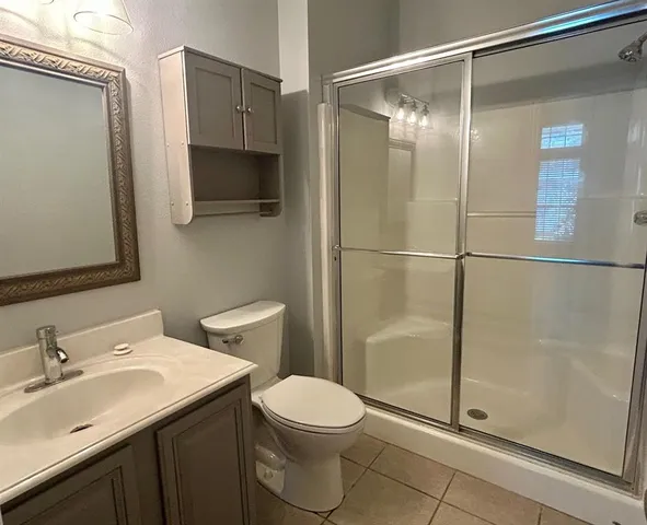 a bathroom with a granite countertop sink toilet and shower