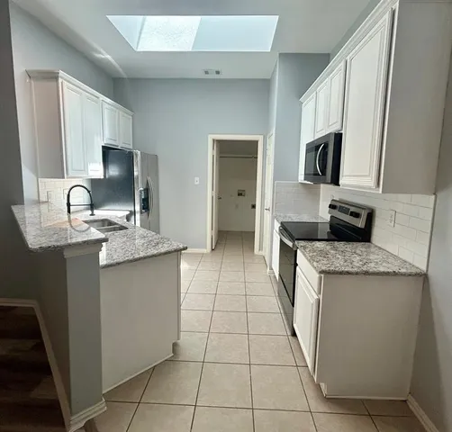a kitchen with stainless steel appliances granite countertop a sink and a stove
