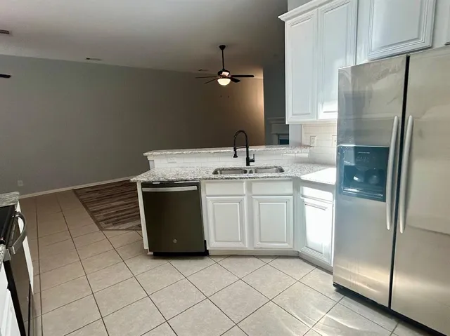 a kitchen with stainless steel appliances a refrigerator sink and microwave