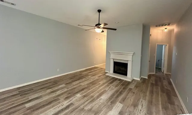 a view of empty room with wooden floor and fireplace