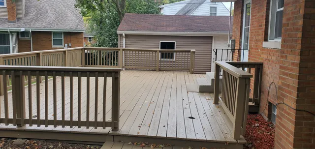 a view of a house with a small yard and wooden fence