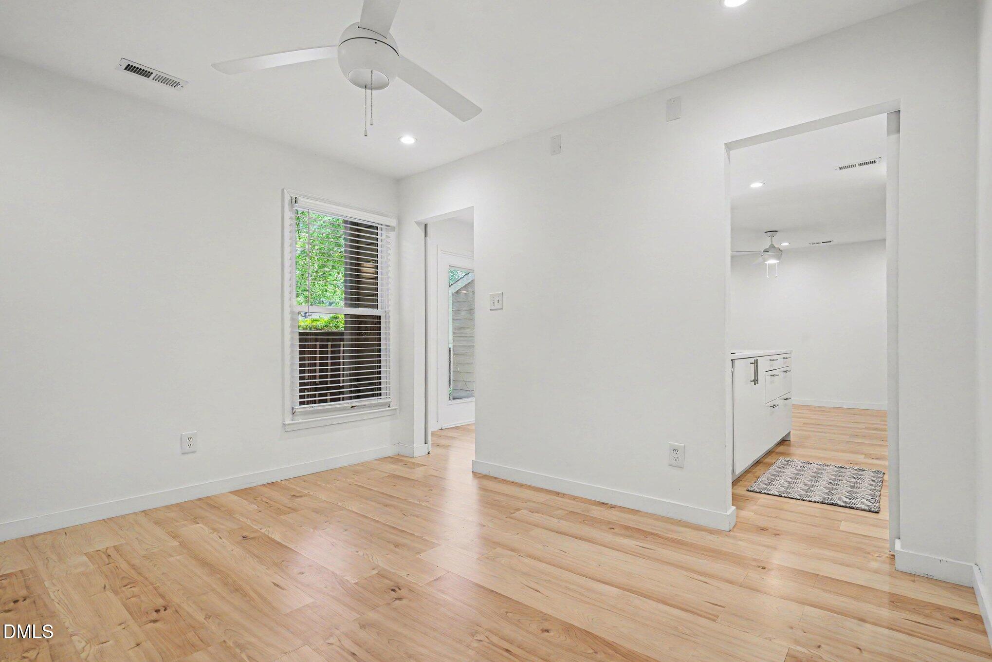 3555 Mill Run Raleigh, NC 27612 - Photo 7 of 25 an empty room with wooden floor and windows