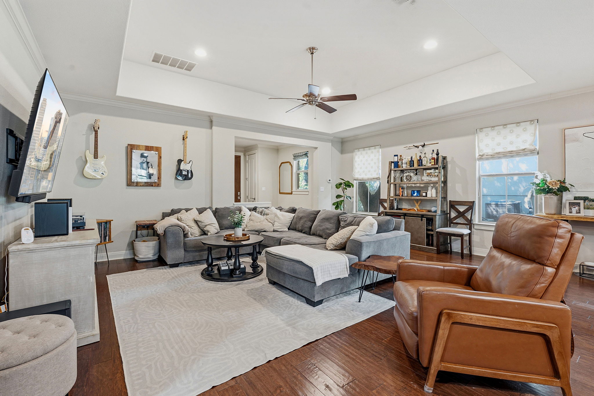 15317 Falconhead Grove Loop Austin, TX 78738 - Photo 2 of 36 Spacious living area featuring wood-finish flooring, a tray ceiling with recessed lighting, and a ceiling fan