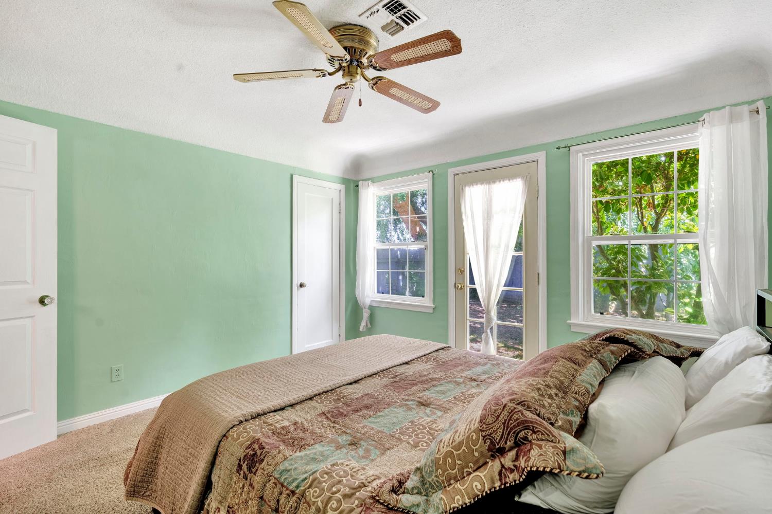 200 Lyons Street Madera, CA 93638 - Photo 26 of 32 a bedroom with a large bed chandelier and a window