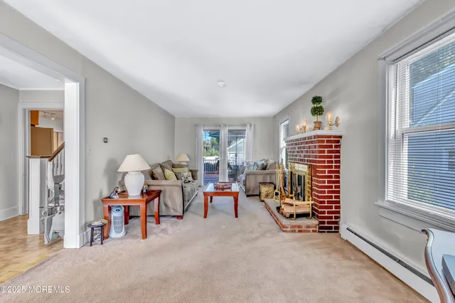 a living room with furniture a fireplace and a window
