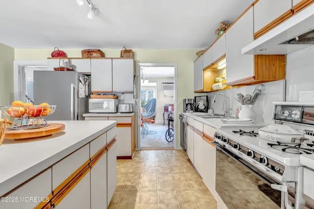 a kitchen with sink stove and refrigerator