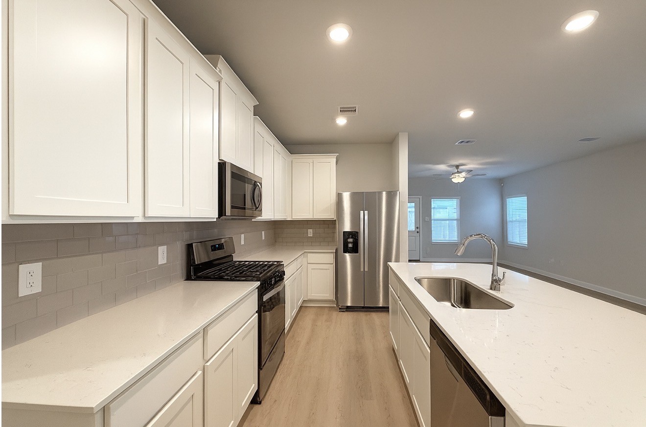 3914 Flora Fld Drive Brookshire, TX 77423 - Photo 6 of 32 a kitchen with a sink a stove and cabinets