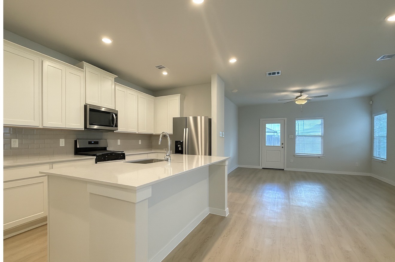 3914 Flora Fld Drive Brookshire, TX 77423 - Photo 7 of 32 a kitchen with stainless steel appliances granite countertop a refrigerator oven a sink dishwasher and white cabinets with wooden floor