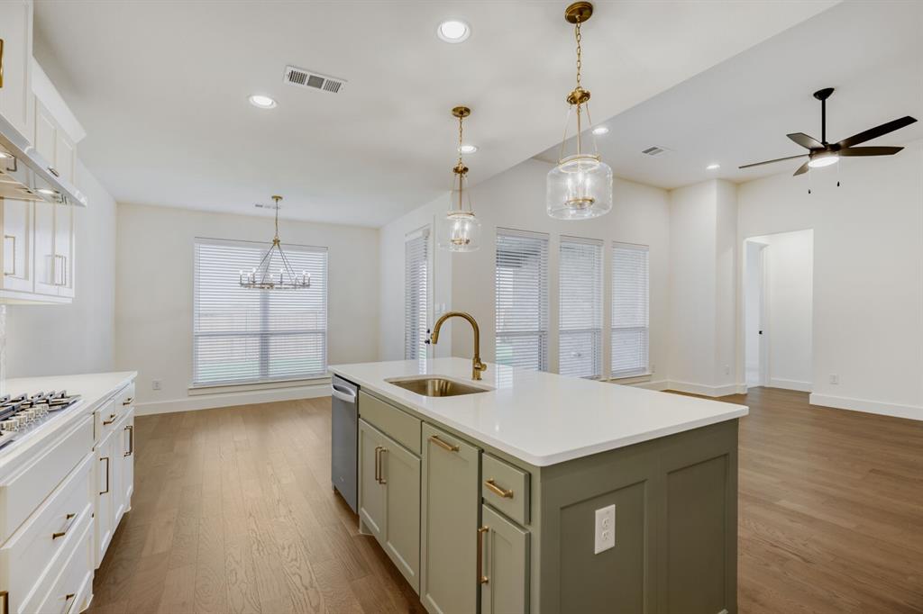 4314 Haley Way Oak Point, TX 75068 - Photo 10 of 28 Spacious open-concept living area featuring a kitchen island with sink, white countertops, and wood-finish flooring