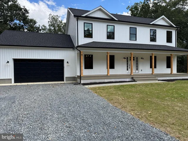 a view of a white house with a yard and garage
