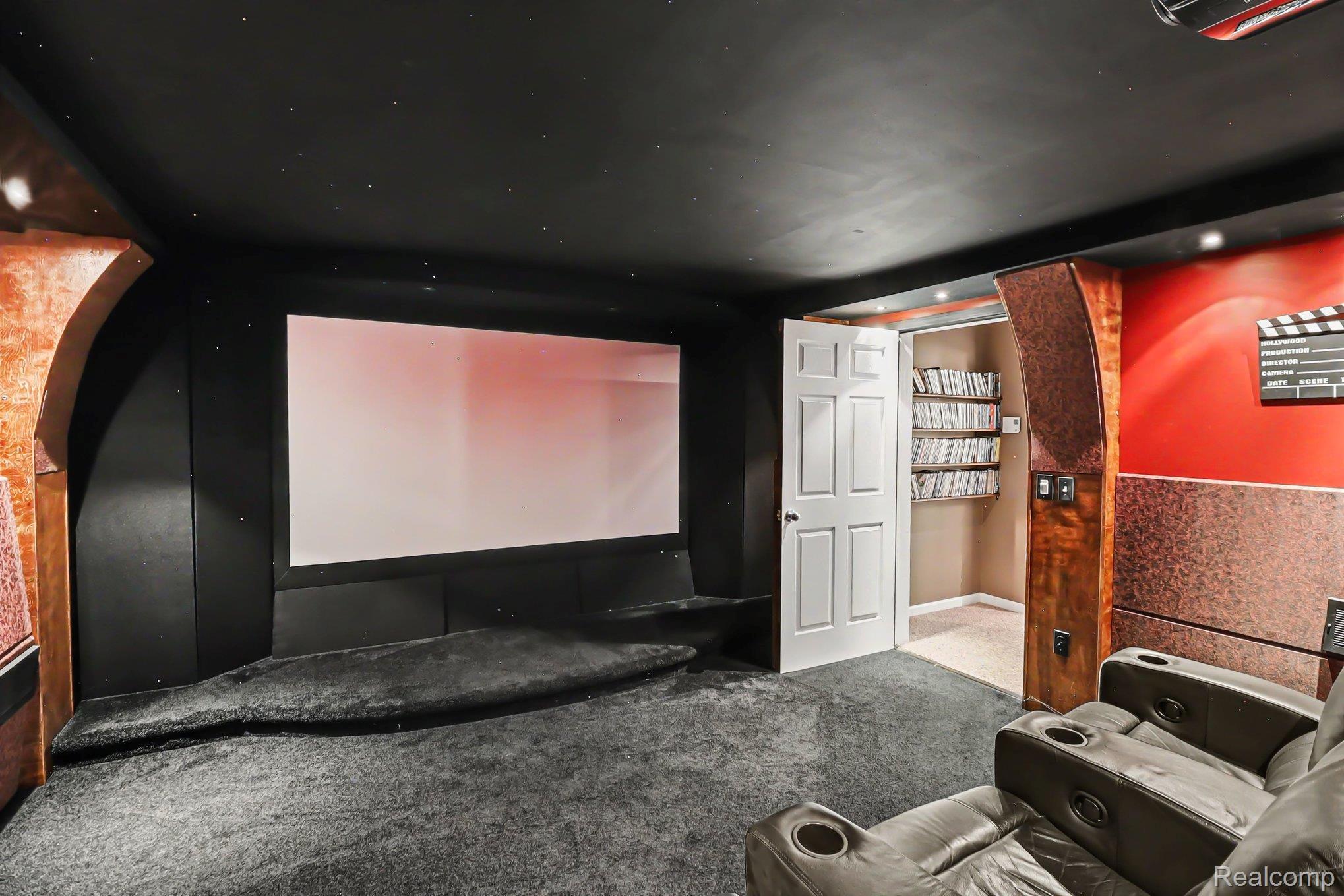 10490 Deer Ridge Trail Holly, MI 48442 - Photo 46 of 56 Dedicated theater room featuring an expansive projection screen, dark wall treatments, and recessed lighting