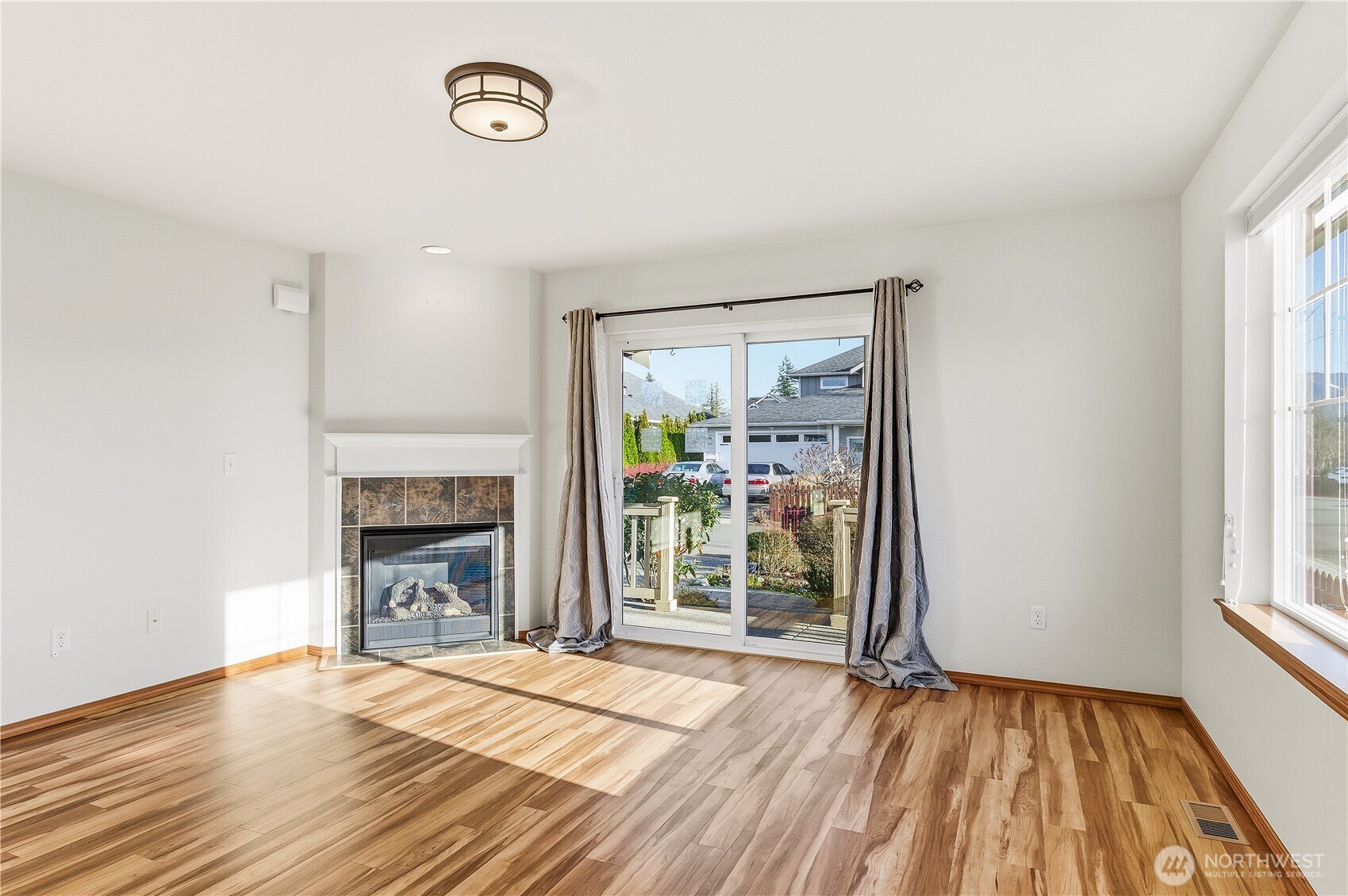 3043 Scotland Alley Mount Vernon, WA 98273 - Photo 14 of 32 an empty room with wooden floor fireplace and windows