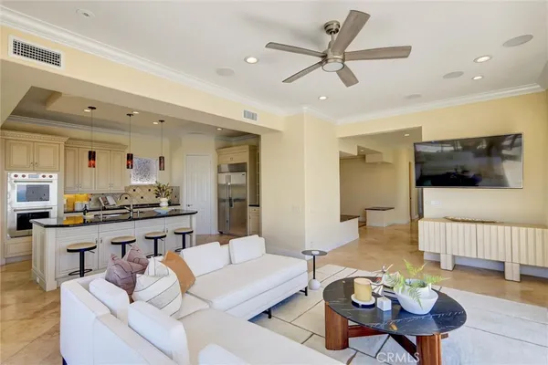 a living room with furniture kitchen view and a flat screen tv
