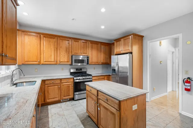 a kitchen with stainless steel appliances granite countertop a stove top oven a refrigerator a sink and dishwasher