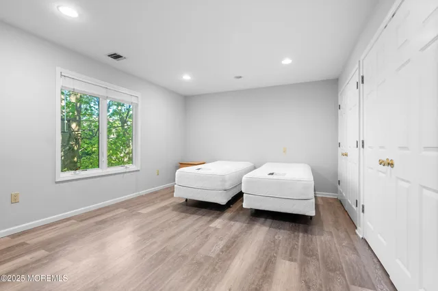 a bedroom with a bed and a view of wooden floor