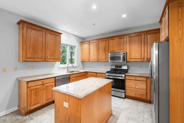 a kitchen with stainless steel appliances granite countertop a stove top oven a sink dishwasher and a refrigerator