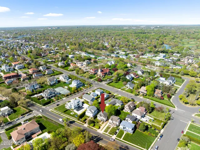 an aerial view of residential houses with outdoor space and trees