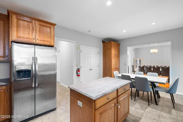 a kitchen with stainless steel appliances granite countertop a refrigerator a stove and a refrigerator with wooden floor