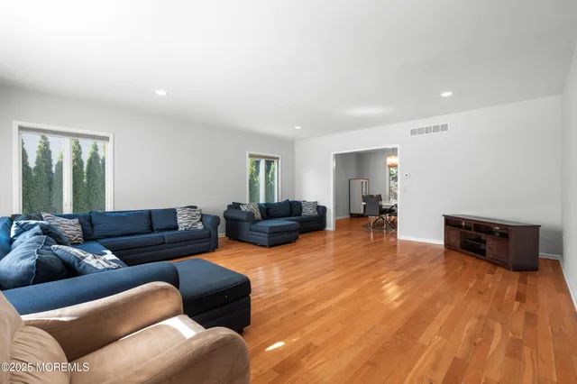 a living room with furniture and a wooden floor