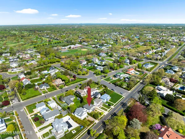 an aerial view of residential houses with outdoor space and trees