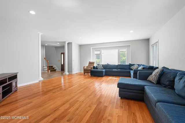 a living room with furniture and a wooden floor