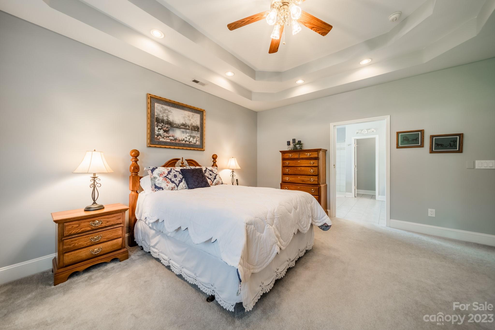 175 Perrin Road Mooresville, NC 28117 - Photo 17 of 45 a spacious bedroom with a bed and a chandelier