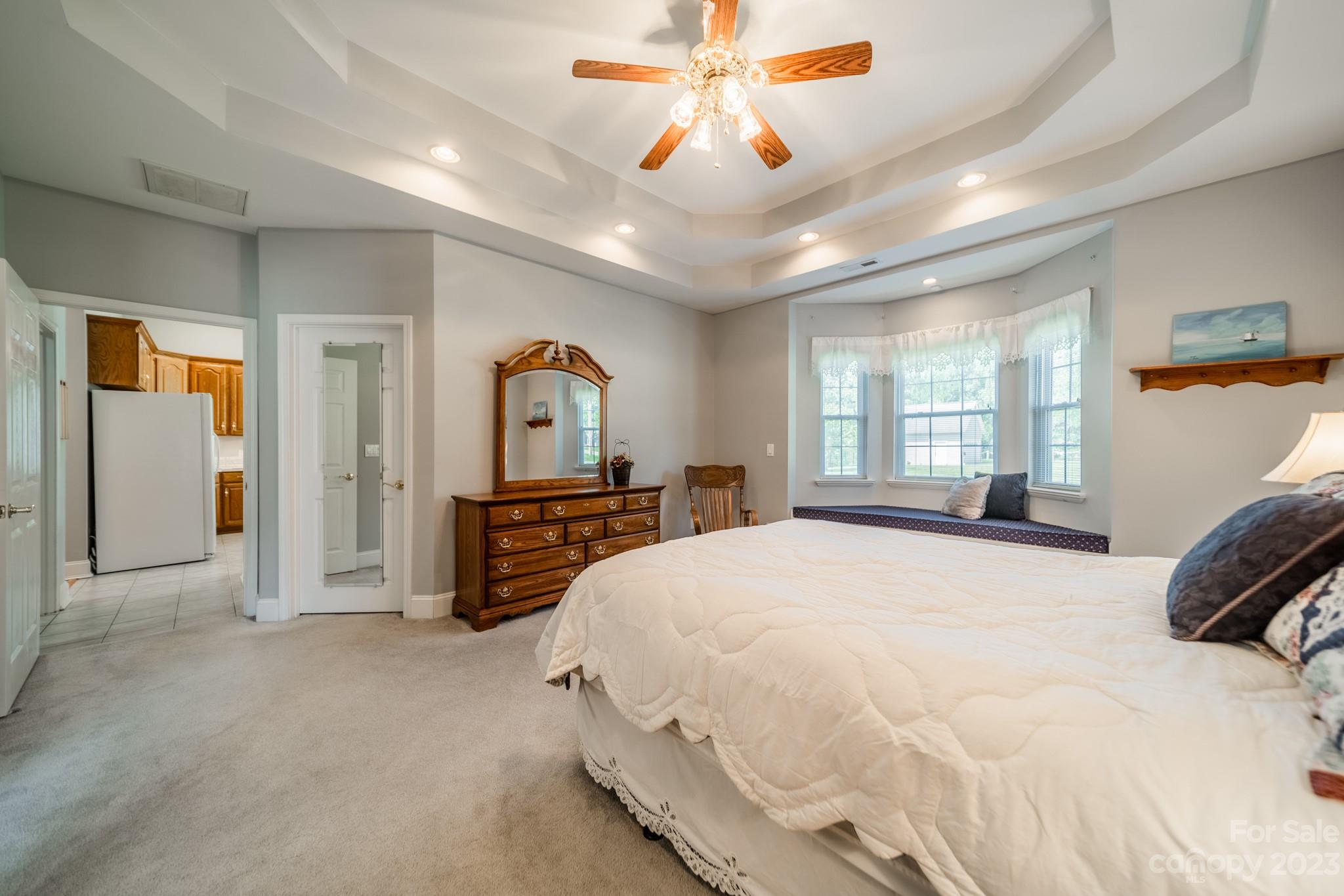 175 Perrin Road Mooresville, NC 28117 - Photo 18 of 45 a spacious bedroom with a bed a dresser and a large window