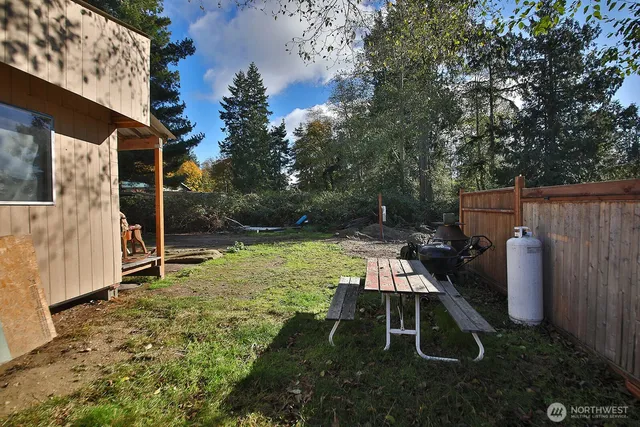 a backyard of a house with table and chairs