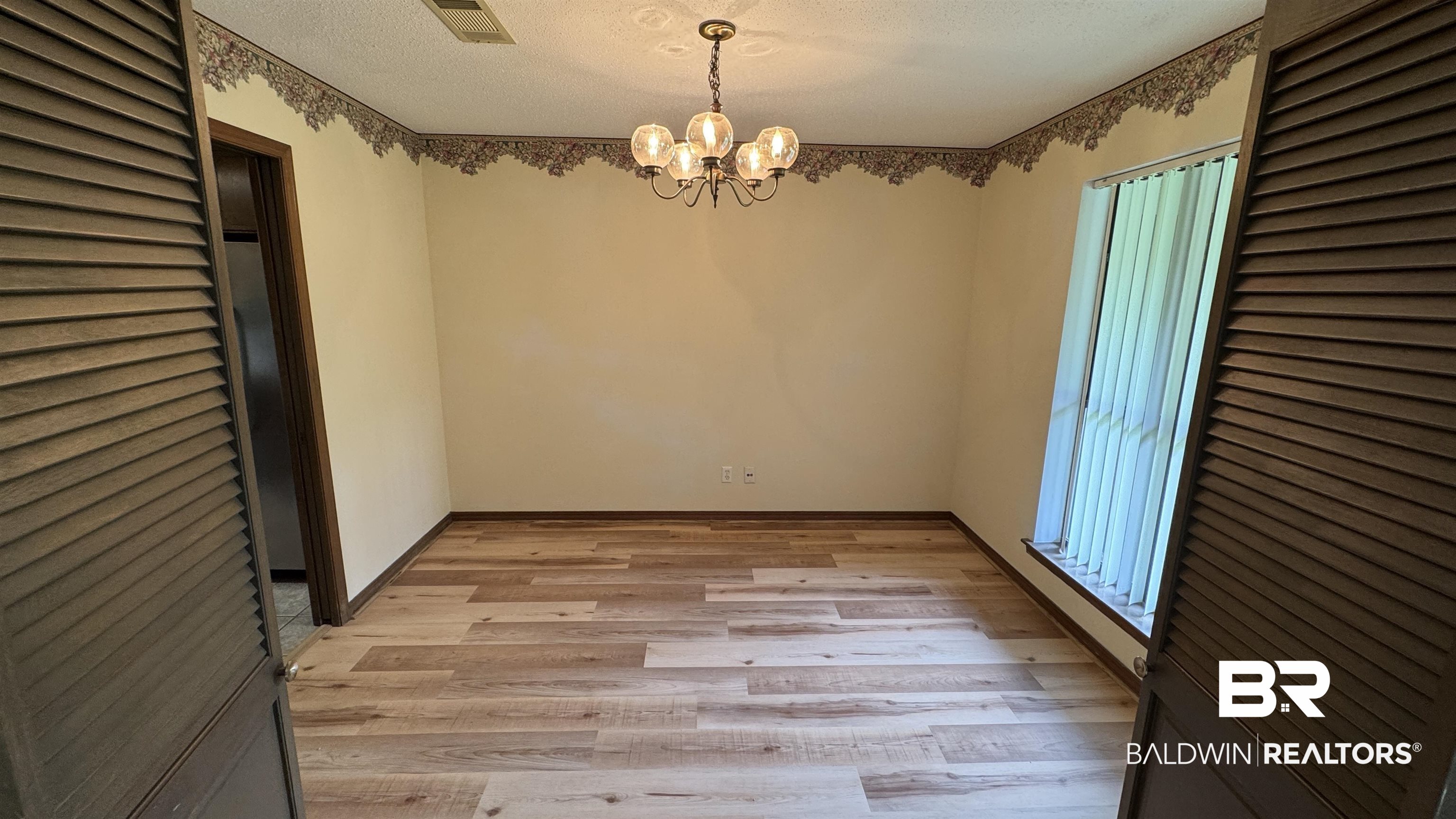 33370 Highway 98 Lillian, AL 36549 - Photo 20 of 58 Spacious interior featuring wood-finish flooring, a contemporary ceiling light fixture, and a window with vertical blinds