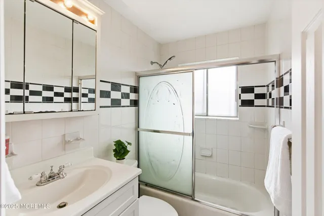a white bath tub sitting next to a white sink and vanity