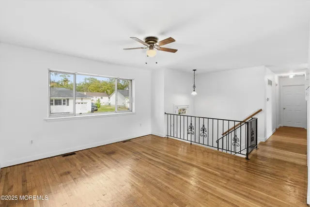 a view of a room with wooden floor and windows