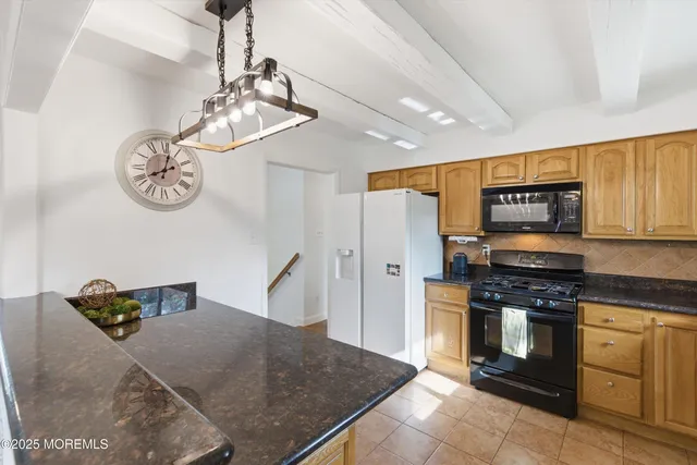 a kitchen with stainless steel appliances granite countertop a stove and cabinets
