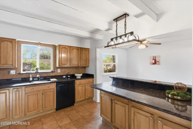 a kitchen with granite countertop a sink a stove and cabinets