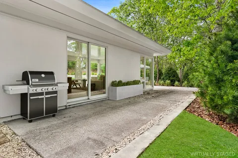 a view of a backyard with couches plants and large trees