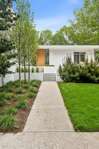 a front view of a house with a yard and potted plants
