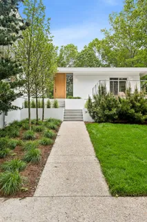 a front view of a house with a yard and potted plants