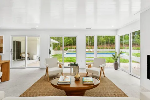 a living room with large couches with a dining table and a couches with wooden floor